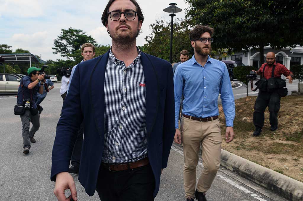 Sembilan pemuda Australia berjalan keluar usai menghadiri sidang di Pengadilan Majistret, Sepang, Malaysia.