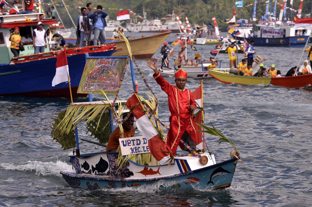 Seorang peserta mengenakan pakaian khas Sulut pada parade Kapal Hias di Selat Lembeh, Bitung, Sulawesi Utara, Kamis (6/10/2016)