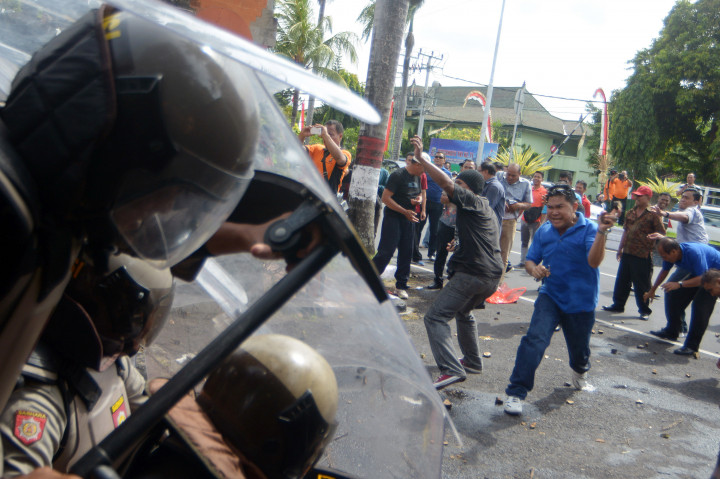 Sejumlah pengunjuk rasa melempar benda keras dan air ke polisi saat simulasi penanganan huru-hara di Pengadilan Negeri Denpasar, Jumat (7/10/2016).
