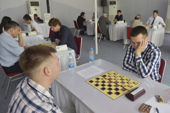 Kontingen Uzbekistan, Samandar Kalanov (kanan), bertanding melawan rekan se-negaranya Alisher Artikov pada ajang International Draughts Competition , Jumat (7/10/2016)