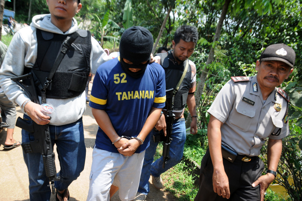 Tersangka AH alias Aji (tengah) menunjukkan lokasi pembuangan jenazah pengikutnya Shendy Eko Budianto dan Ahmad Sanusi saat olah TKP di kawasan Kecamatan Limo, Depok, Jawa Barat, Jum'at (7/10/2016). 