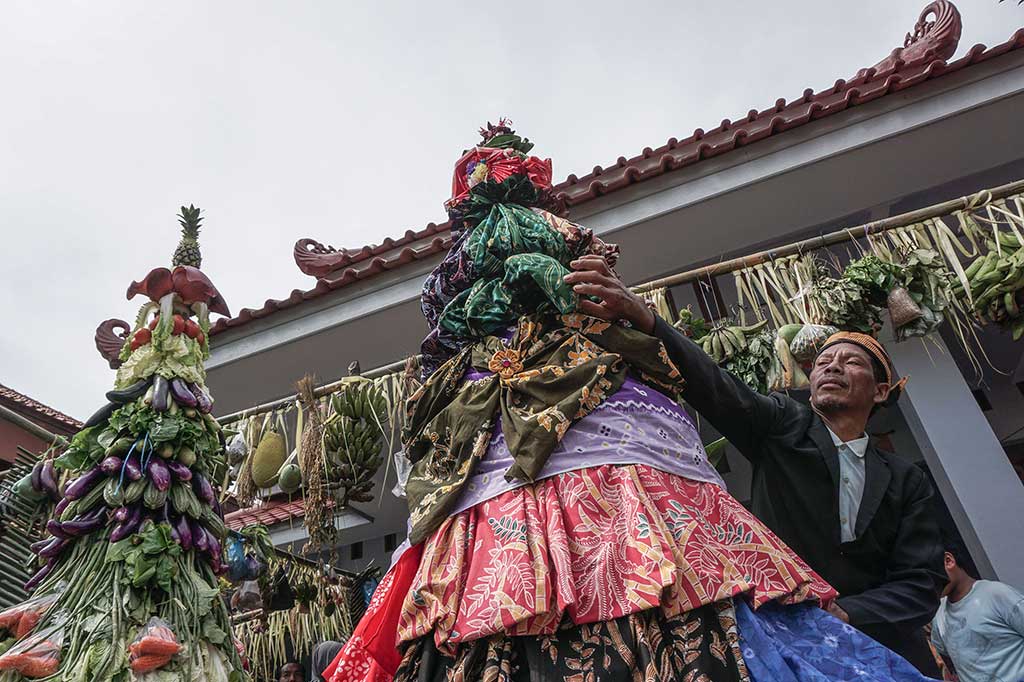 Tetua adat merapikan gunungan yang terbuat dari kain batik tradisional banyumasan acara sedekah bumi di Desa Papringan, Banyumas.