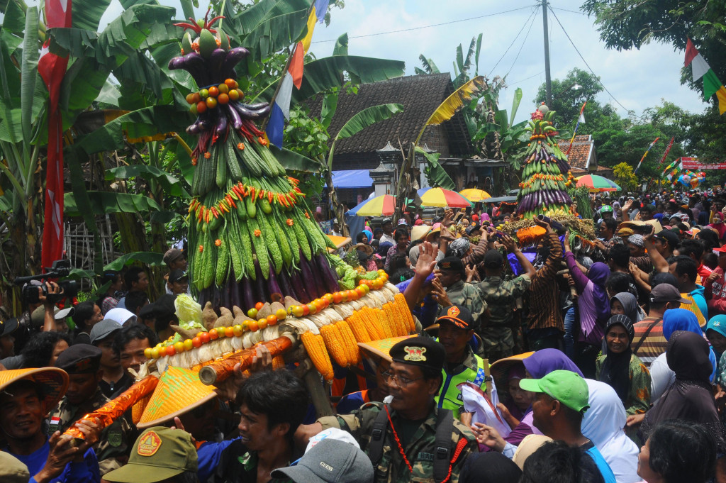 Sejumlah warga membawa gunungan hasil pertanian yang berlimpah saat kirab tradisi sebar udik-udik di Soropaten, Karangnom, Klaten, Jawa Tengah, Minggu (9/10/2016).