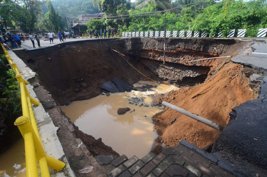 Sejumlah warga menyaksikan jembatan Ketapangjaya yang ambles di Kampung Purwaharja, Kota Banjar, Jawa Barat, Senin (10/10/2016).