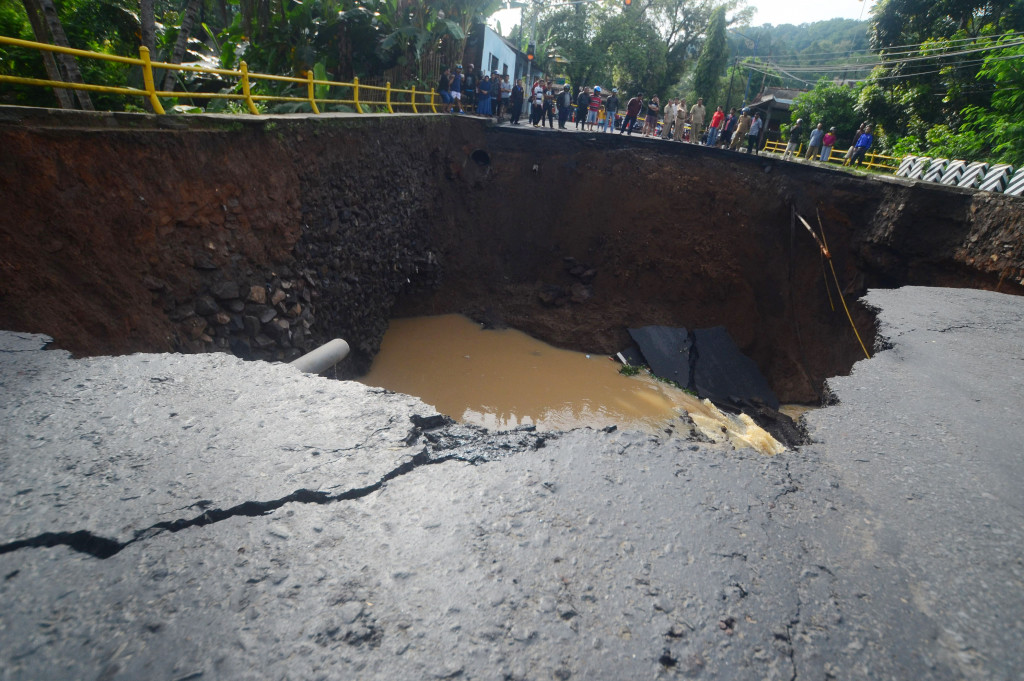 Sejumlah warga menyaksikan jembatan Ketapangjaya yang ambles di Kampung Purwaharja, Kota Banjar, Jawa Barat, Senin (10/10/2016).
