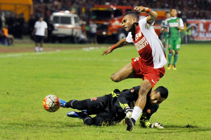 Pesepakbola PSM Makassar Titus Bonai berjibaku dengan penjaga gawang PS TNI Dhika Bhayangkara.