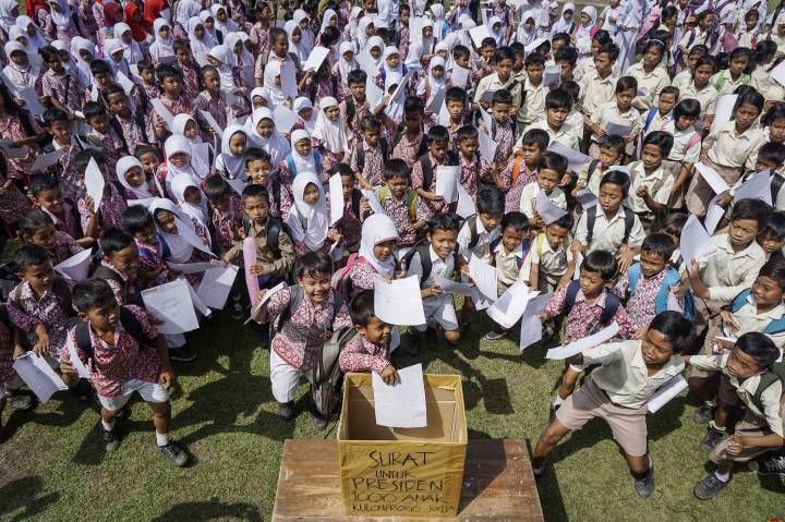 Ratusan siswa sekolah dasar menuliskan surat untuk Presiden Joko Widodo di halaman SD Negeri Sendangsari, Pengasih, Kulonprogo, DI Yogyakarta, Rabu (12/10/2016)