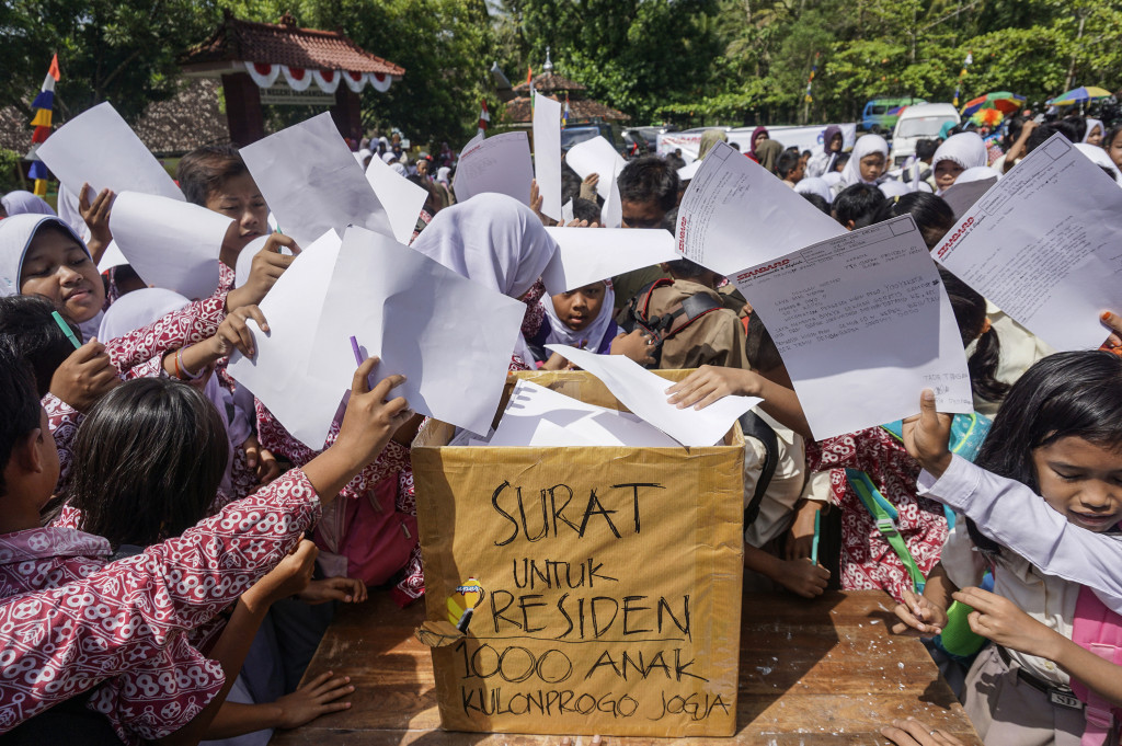 Ratusan siswa sekolah dasar menuliskan surat untuk Presiden Joko Widodo di halaman SD Negeri Sendangsari, Pengasih, Kulonprogo, DI Yogyakarta, Rabu (12/10/2016)