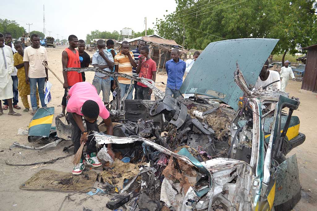 Warga berkumpul di lokasi ledakan bom bunuh diri di Maiduguri, timur laut Borno, Nigeria, Rabu.