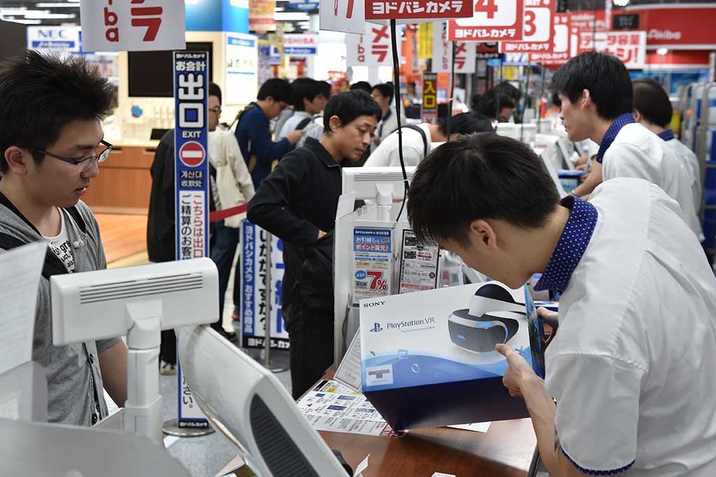 Karyawan menerangkan produk PSVR kepada pelanggan.