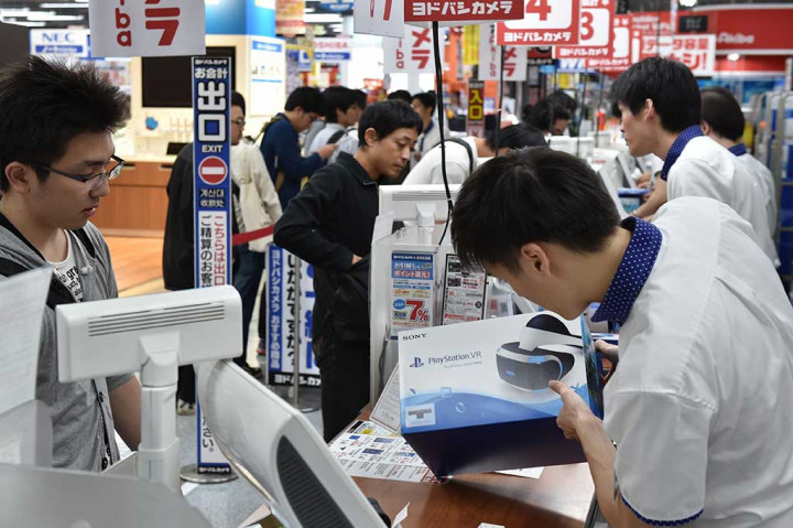 Karyawan menerangkan produk PSVR kepada pelanggan.