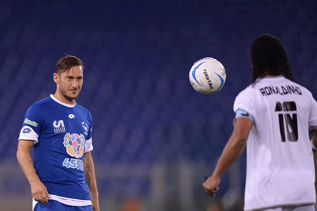 Francesco Totti melakukan pemanasan bersama Ronaldinho.