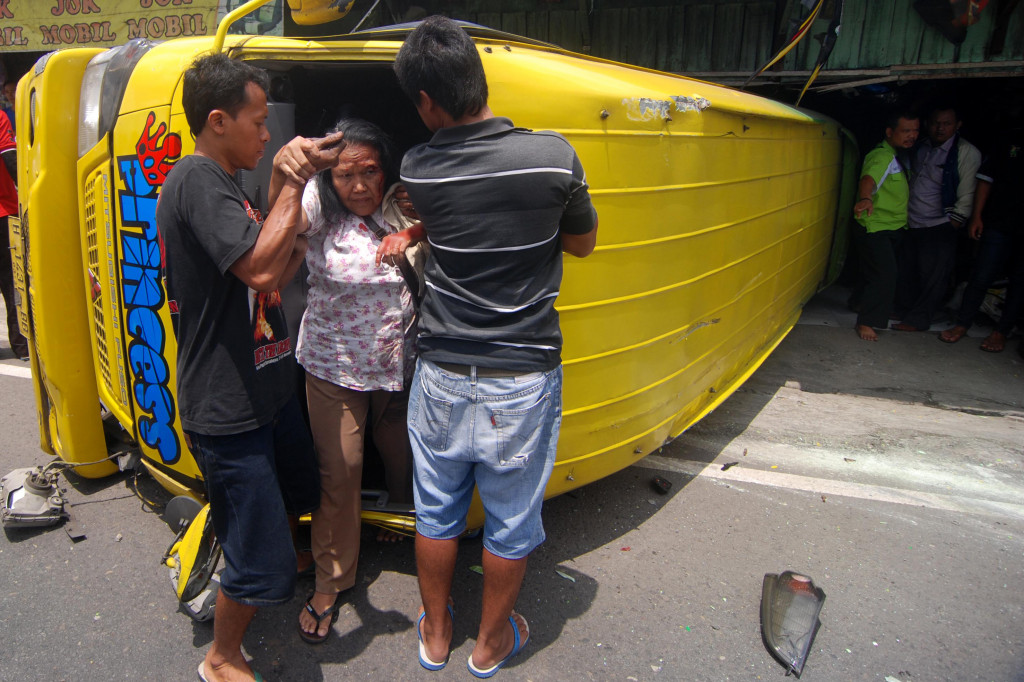 Sejumlah warga berusaha mengevakuasi penumpang korban kecelakaan dari dalam minibus di Jalan Raya Semarang-Bawen KM 23, Semarang, Jawa Tengah, Kamis (13/10/2016).