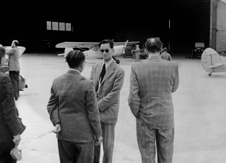 Bhumibol Adulyadej (tengah, berkacamata) di bandara Thailand menjelang perjalanannya ke Inggris pada 8 Agustus 1949.