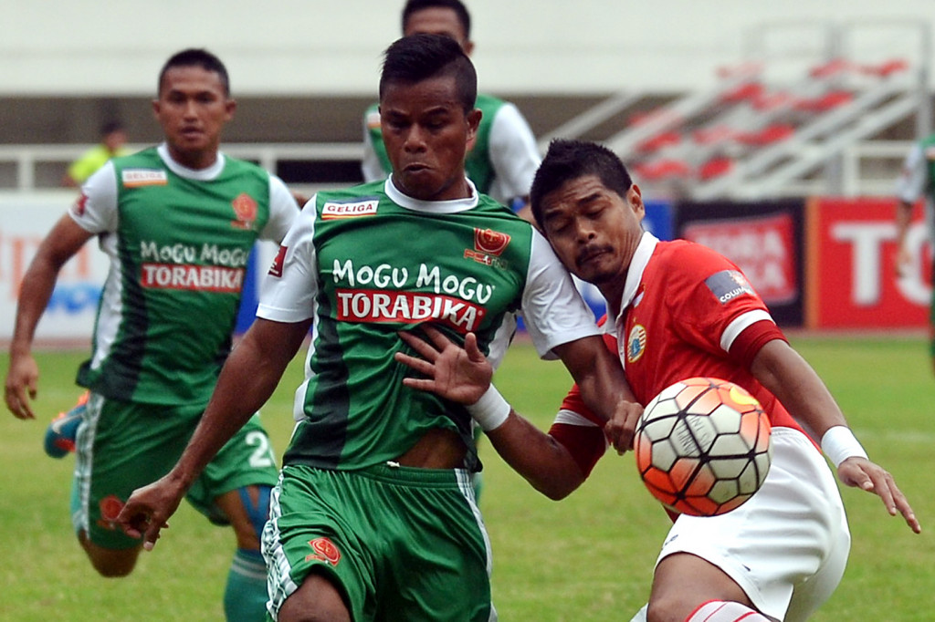 Pesepak bola Persija Bambang Pamungkas (kanan) saat berebut bola dengan pesepak bola PS TNI Manahati Lestusen (tengah) di Stadion Pakansari, Cibinong, Jawa Barat, Jumat (14/10/2016).