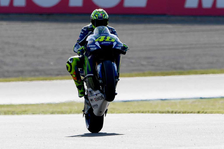 Pembalap Movistar Yamaha Valentino Rossi melakukan selebrasi dengan mengangkat ban depan motornya usai merebut pole position dalam kualifikasi MotoGP Jepang di Sirkuit Motegi, Sabtu.