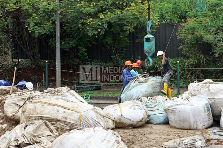 Pekerja mempersiapkan pasir untuk diangkut dengan crane ke atas gedung milik Panin Bank di Bintaro Sektor 7, Tangerang Selatan, yang hendak dirobohkan.