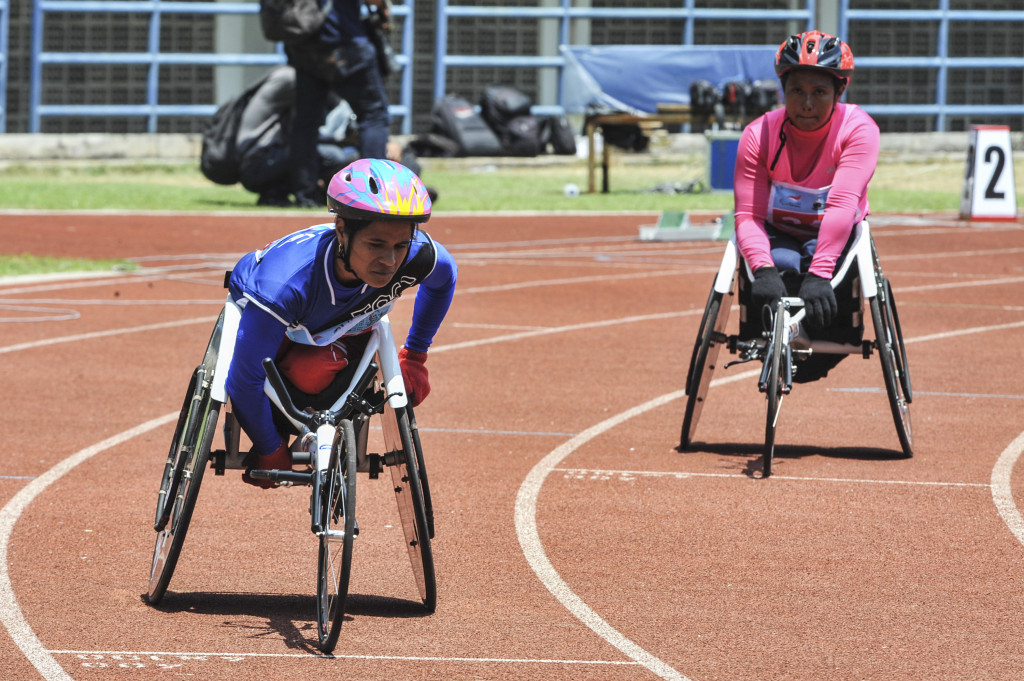 Atlet Paralimpik Balap Kursi Roda asal Kalsel Mulyani (kiri) memacu kursi roda balapnya pada pertandingan atletik balap kursi roda 400 meter Peparnas XV di Stadion Gelora Bandung Lautan Api, Bandung, Minggu (16/10/2016)