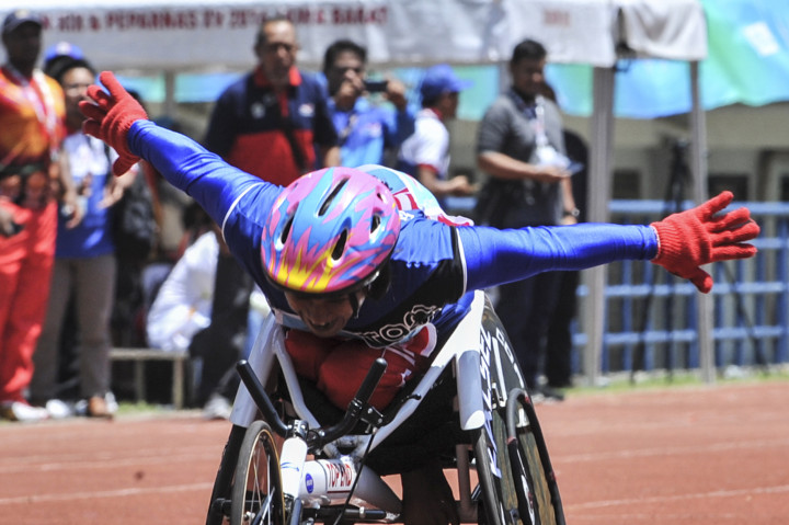 Atlet Paralimpik Balap Kursi Roda asal Kalsel Mulyani (kiri) memacu kursi roda balapnya pada pertandingan atletik balap kursi roda 400 meter Peparnas XV di Stadion Gelora Bandung Lautan Api, Bandung, Minggu (16/10/2016)