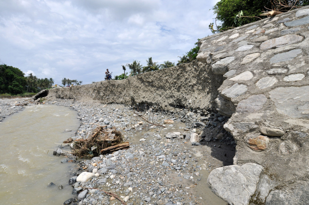 Pengendara sepeda motor melaju di jalan yang ambles di Kelurahan Pantoloan Boya, Kota Palu, Sulawesi Tengah, Senin (17/10/2016)