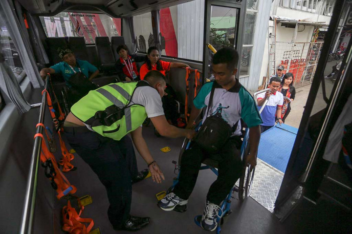Petugas membantu atlet yang hendak masuk ke dalam bus seusai mengikuti pertandingan pada ajang Peparnas XV di Bandung.