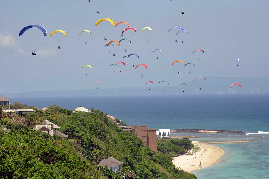 Sebanyak 110 pilot Paralayang membuat rekor MURI untuk terbang bersama di Gunung Payung, Nusa Dua, Bali pada Minggu (16/10). Di latar belaang adalah Pulau Lombok. 