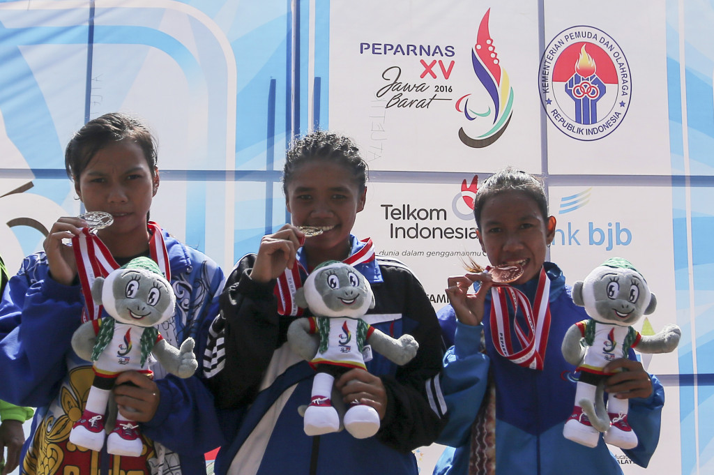 Atlet lompat jauh asal Jabar Astri Cahyati (tengah) bersama atlet DI Yogyakarta Anggun Novita Dewi (kiri) dan atlet Kalsel Desy Apriani berfoto bersama usai mengikuti upacara penyerahan medali pada nomor lompat jauh klasifikasi F54 putri Peparnas XV di Stadion Gelora Bandung Lautan Api, Bandung, Jawa Barat, Selasa (18/10/2016)