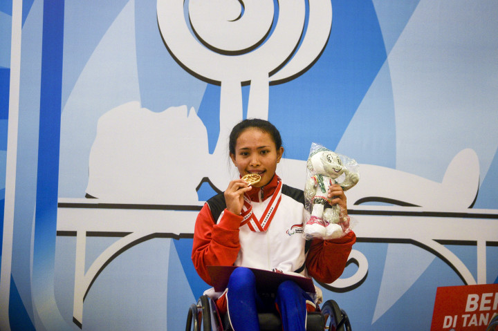 Atlet angkat berat provinsi Bali Ni Nengah Widiasih menggigit medali emas usai menjadi juara pada kelas 41 kg putri cabor angkat berat Peparnas XV di Hotel Preanger, Bandung, Jawa Barat, Selasa (18/10/2016)