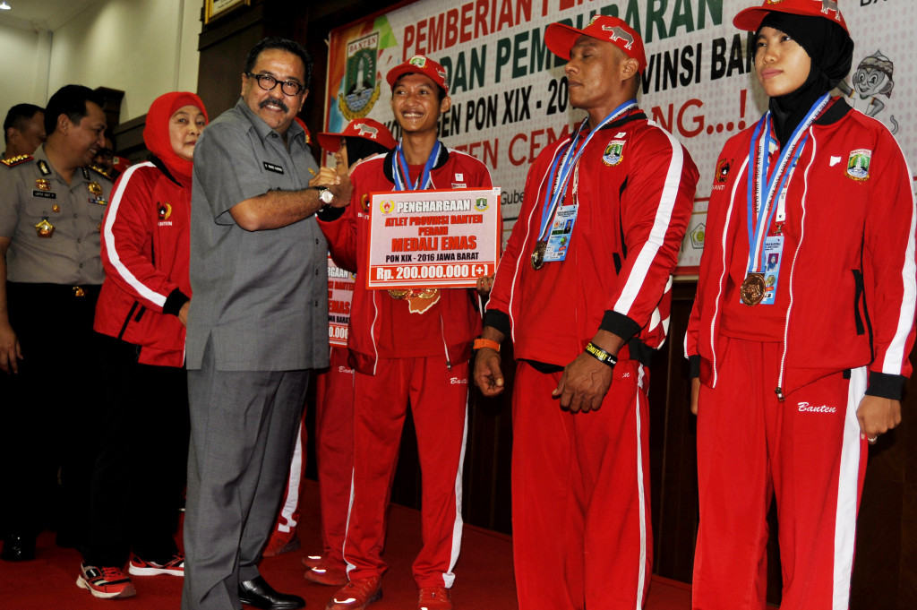 Gubernur Banten Rano Karno (ketiga kiri) didampingi Ketua KONI Banten Rumiah (kedua kiri) menyerahkan hadiah Rp200 juta untuk atlet peraih medali emas pada PON XIX di Pendopo Gubernur Banten, Serang, Banten, Selasa (18/10/2016)