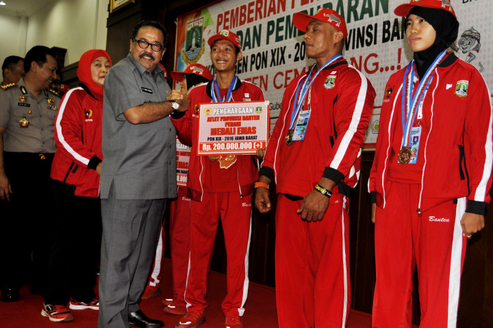 Gubernur Banten Rano Karno (ketiga kiri) didampingi Ketua KONI Banten Rumiah (kedua kiri) menyerahkan hadiah Rp200 juta untuk atlet peraih medali emas pada PON XIX di Pendopo Gubernur Banten, Serang, Banten, Selasa (18/10/2016)