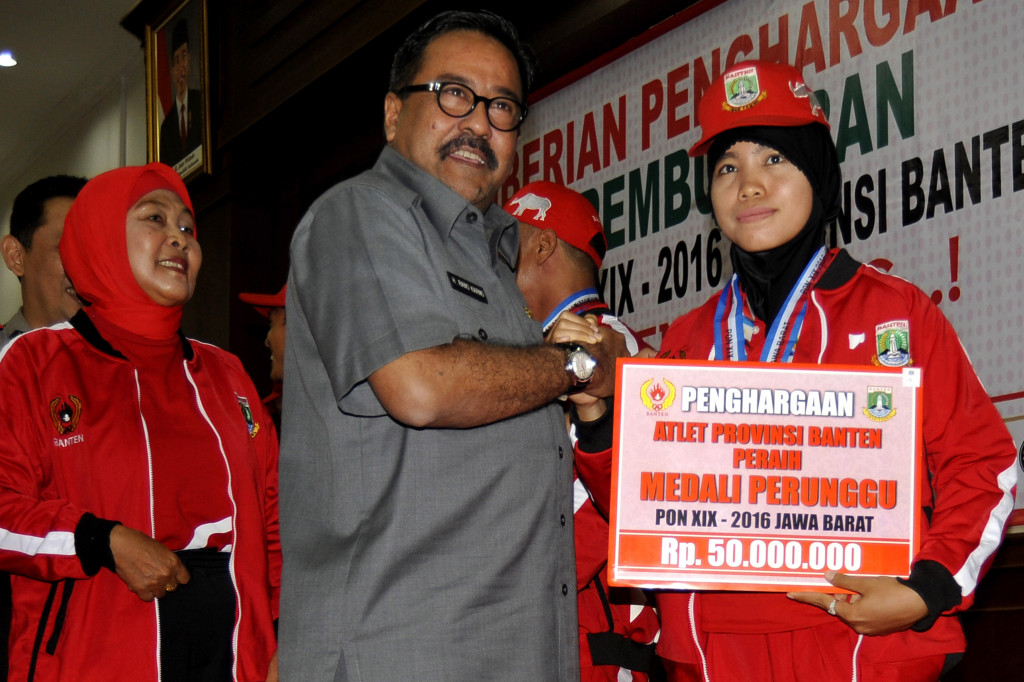 Gubernur Banten Rano Karno (tengah) didampingi Ketua KONI Banten Rumiah (kiri) menyerahkan hadiah Rp50 juta untuk atlet peraih medali perak pada PON XIX di Pendopo Gubernur Banten, Serang, Banten, Selasa (18/10/2016)