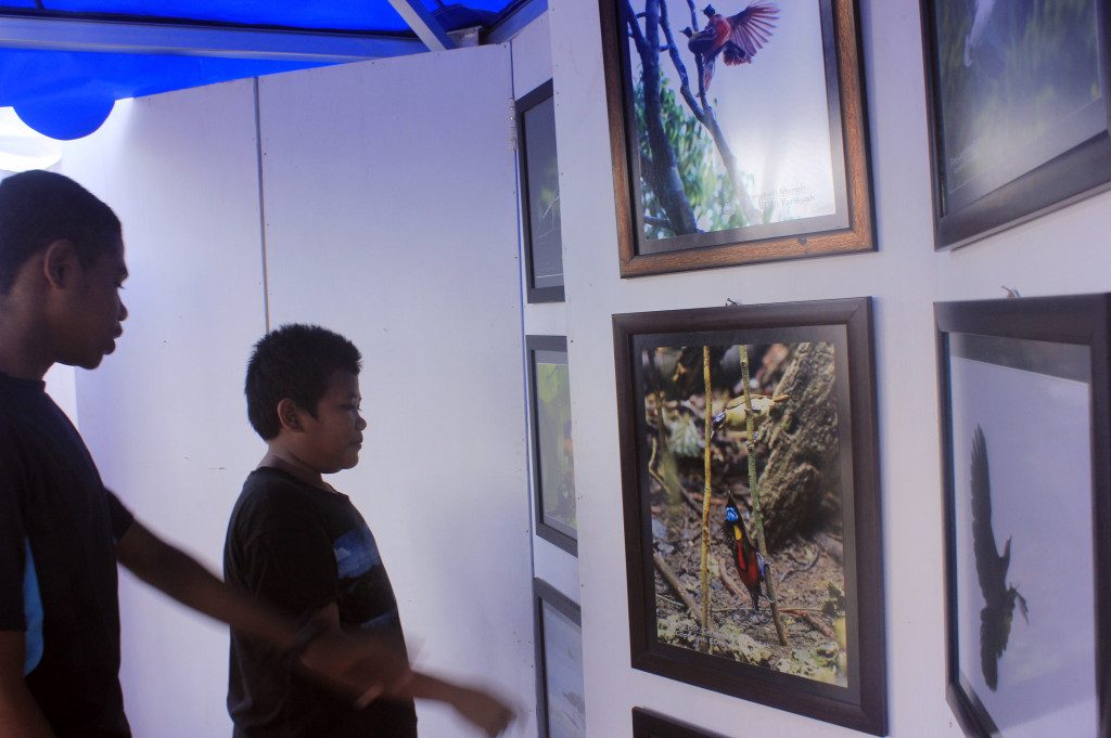 Pengunjung melihat Pameran Foto pada Festival Pesona Raja Ampat di Pantai Waisai Torang Cinta (WTC) Raja Ampat, Papua Barat, Selasa (18/10/2016)