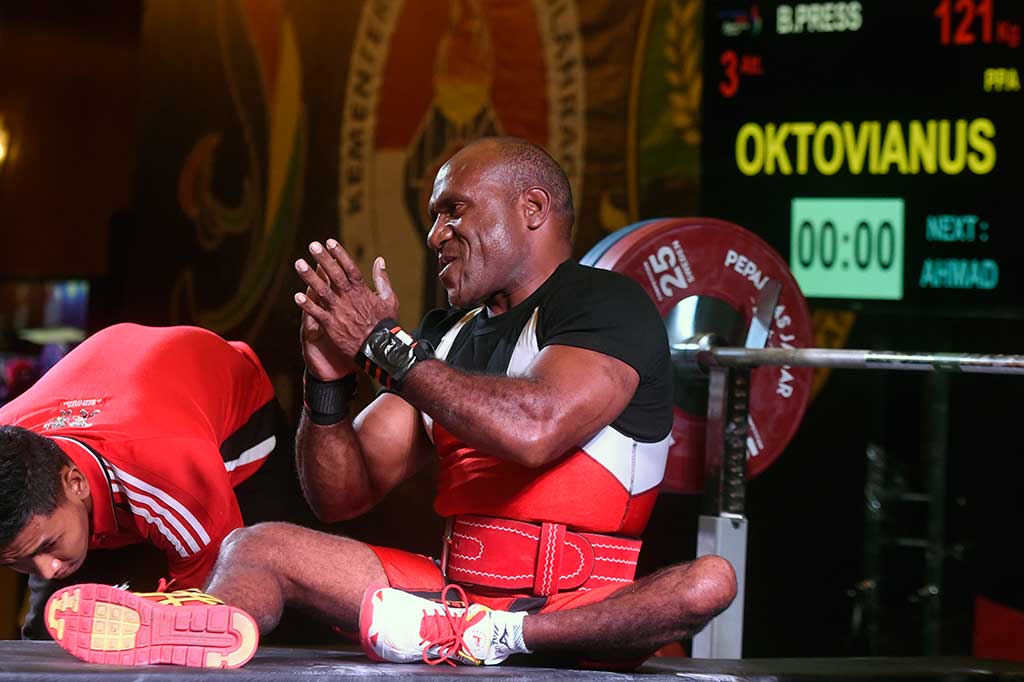 Atlet Papua, Oktovianus F Itlay bertepuk tangan usai melakukan angkatan pada kelas 59 kg Putra Peparnas XV.