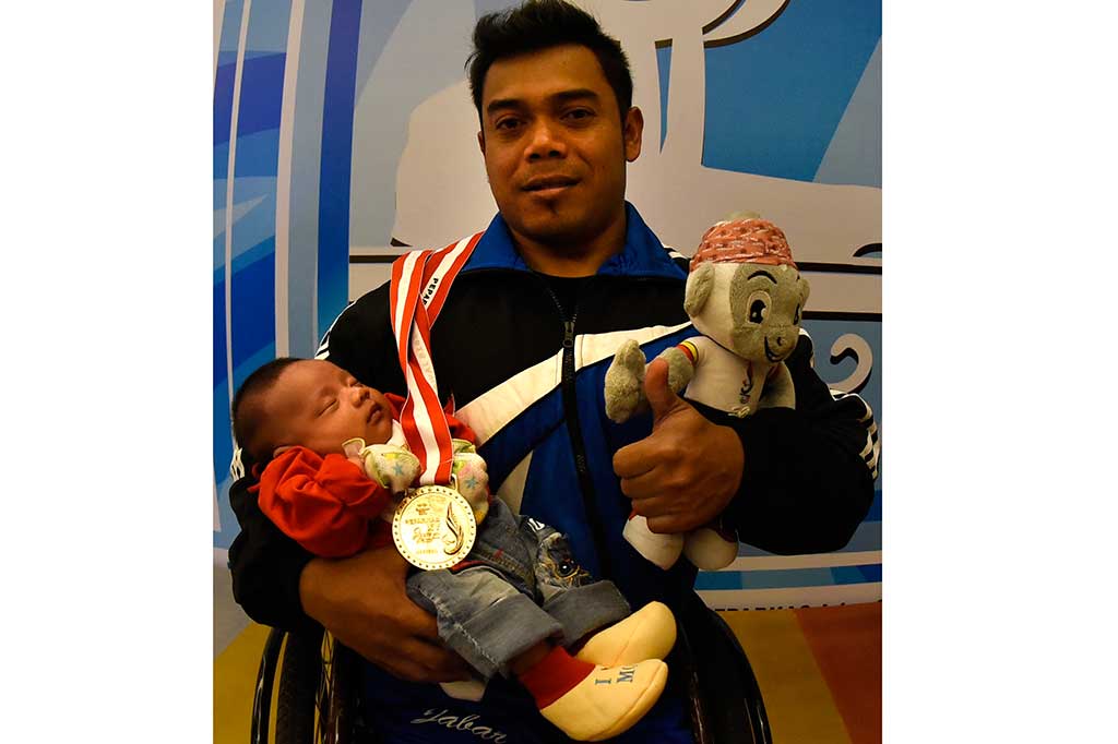 Ahmad Hidayat berfoto bersama anaknya setelah menjuarai angkat berat kelas 59 kg putra Peparnas XV.