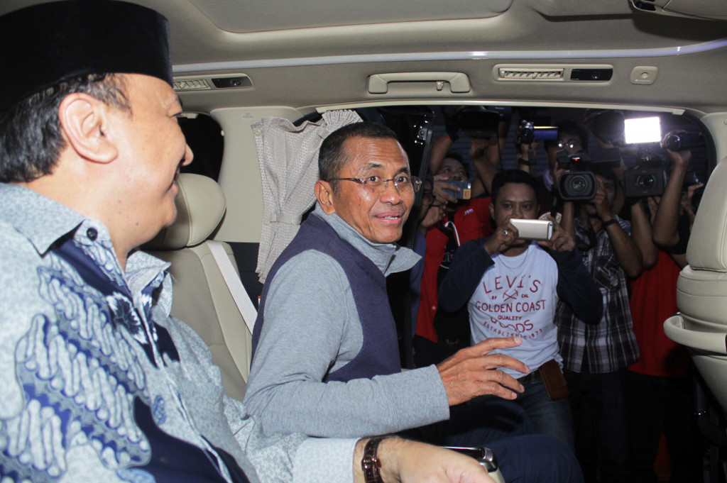 Mantan Menteri BUMN Dahlan Iskan (kanan) berada di dalam kendaraan usai diperiksa terkait kasus dugaan korupsi penjualan aset PT PWU di Kejaksaan Tinggi Jawa Timur, Surabaya, Rabu (19/10/2016).