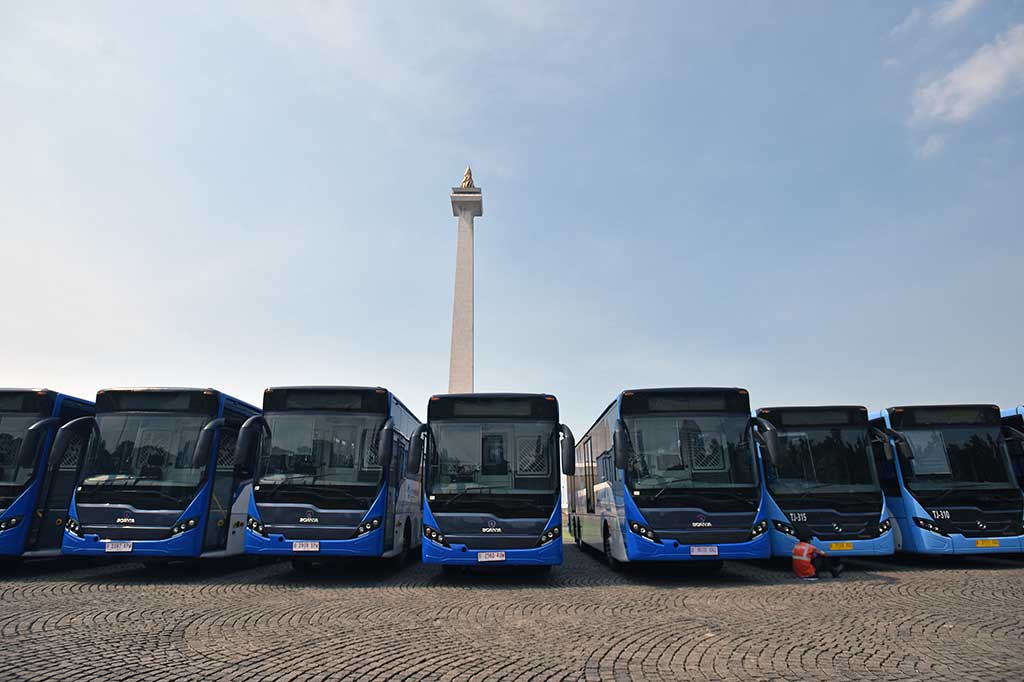 Petugas berada di antara armada baru bus TransJakarta yang diparkir di Kawasan Monas, Jakarta.
