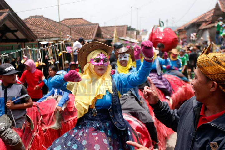 Warga mengikuti arak-arakan sebelum acara tradisi Perang Tomat di Kampung Cikareumbi, Desa Cikidang, Kecamatan Lembang, Kabupaten Bandung Barat, Jawa Barat, Rabu.