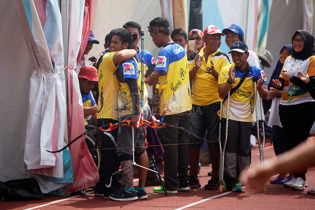 M Nurhadi dipeluk rekan setim dan ofisial seusai memenangkan final panahan nomor recurve aduan perorangan terbuka putra.