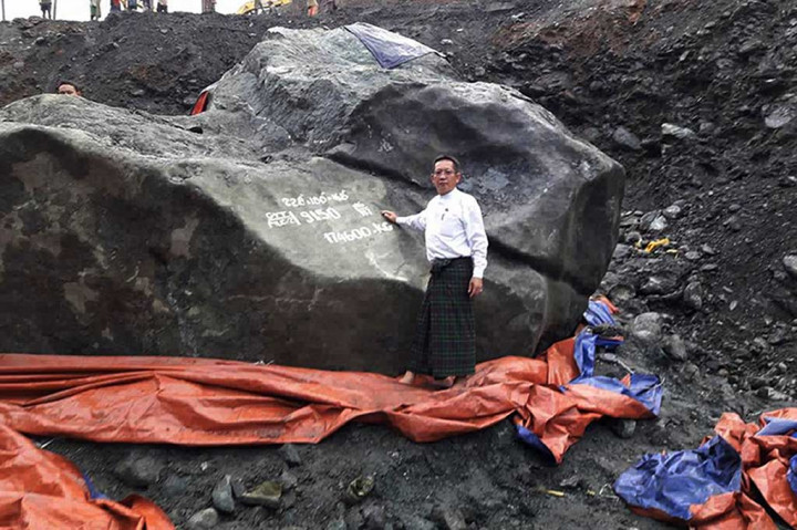 Seorang anggota parlemen berfoto dengan latar belakang batu giok raksasa di Hpakant, utara negara bagian Kachin.