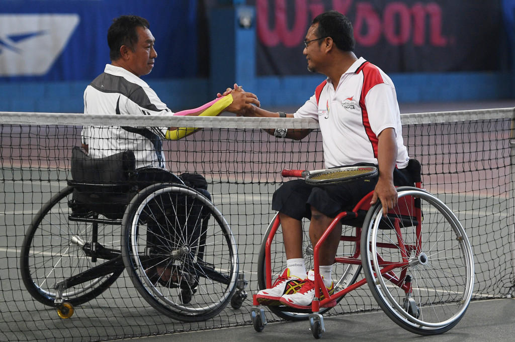 Petenis Papua Maryanta (kanan) bersalaman dengan petenis Kaltim Erwin S usai bertanding dalam final tenis lapangan kursi roda tunggal putra quad Peparnas XV di Lapangan Tenis Indoor Siliwangi, Bandung, Jabar, Jumat (21/10/2016)