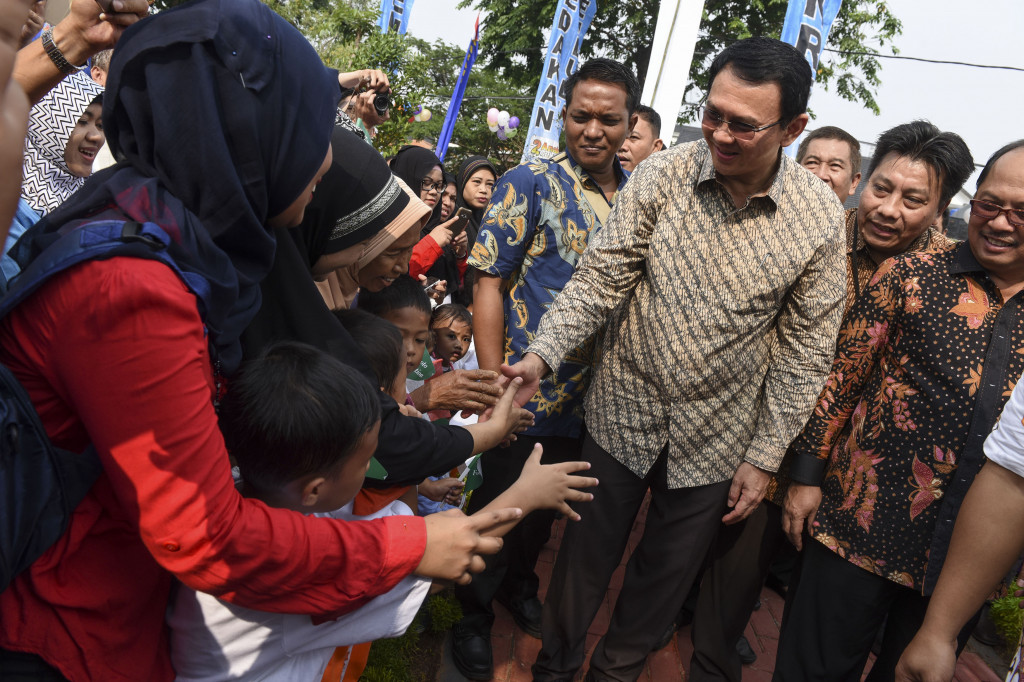 Gubernur DKI Jakarta Basuki Tjahaja Purnama (ketiga kanan) bersalaman dengan warga saat peresmian Ruang Publik Terpadu Ramah Anak (RPTRA) Akasia di Tebet, Jakarta, Jumat (21/10/2016)