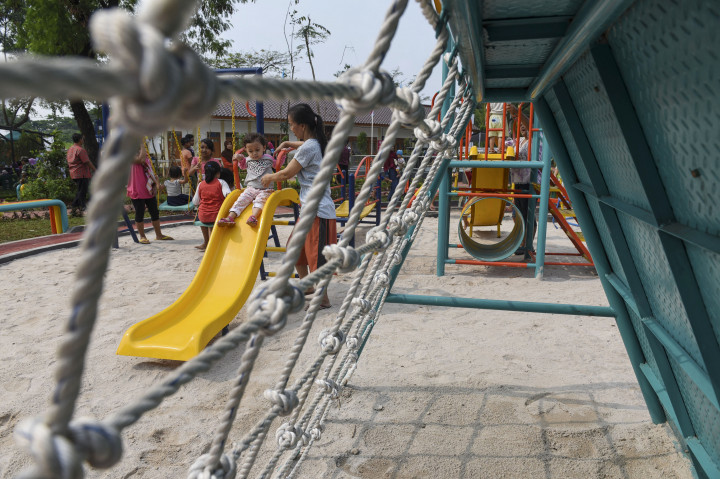 Seorang ibu mendampingi anaknya yang sedang bermain di Ruang Publik Terpadu Ramah Anak (RPTRA) Akasia setelah diresmikan Gubernur DKI Jakarta Basuki Tjahaja Purnama di Tebet, Jakarta, Jumat (21/10/2016)