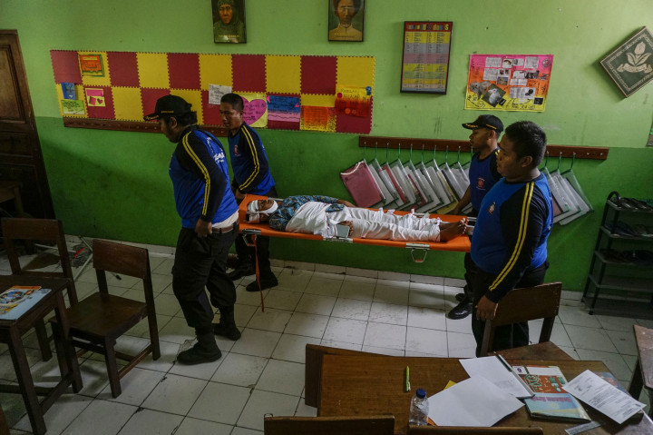 Petugas Taruna Siaga Bencana (TAGANA) mengevakuasi korban gempa saat simulasi bencana gempa bumi di SD Muhammadiyah Karangkajen, Mergangsan, DI Yogyakarta, Jumat (21/10/2016).