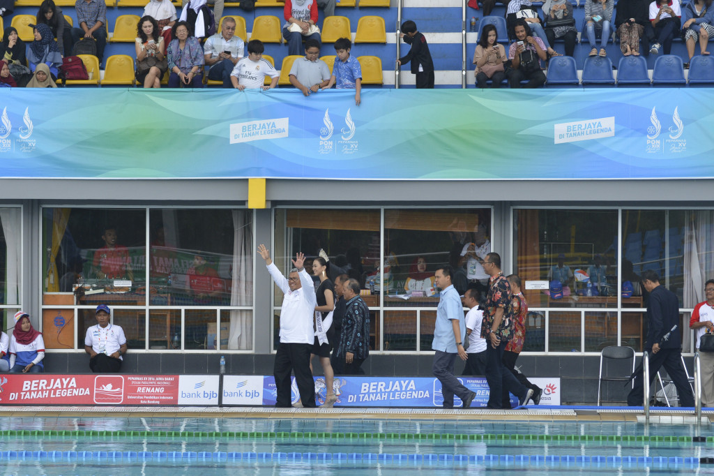 Gubernur Jawa Barat Ahmad Heryawan (kiri) bersama Rektor UPI Furqon (ketiga kiri) melambaikan tangan usai menyaksikan final renang Peparnas XV di Kolam Renang FPOK UPI, Bandung, Jawa Barat, Jumat (21/10/2016)