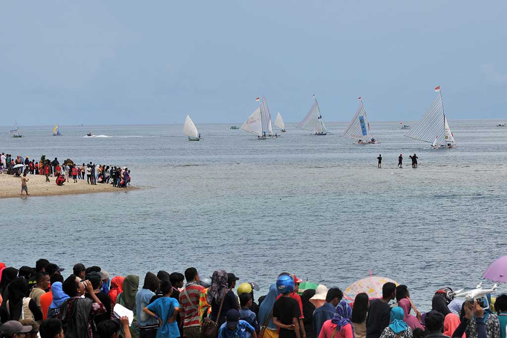 Warga menyaksikan lomba perahu layar Festival Pesona Teluk Tomini 2016 di Parigi, Parigi Moutong.