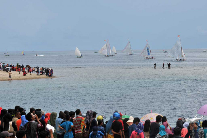 Warga menyaksikan lomba perahu layar Festival Pesona Teluk Tomini 2016 di Parigi, Parigi Moutong.