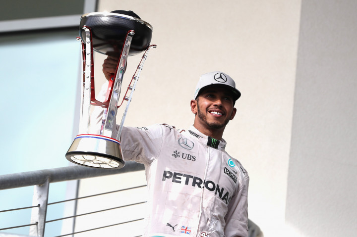 Lewis Hamilton mengangkat trofi kemenangannya di Circuit of the Americas