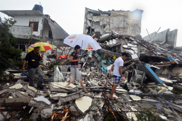 Warga diantara reruntuhan bangunan dua lantai Pizza Hut Delivery yang luluh lantah di Jalan Raya Hankam, Jati Melati, Bekasi, Jawa Barat, Minggu (23/10/2016)