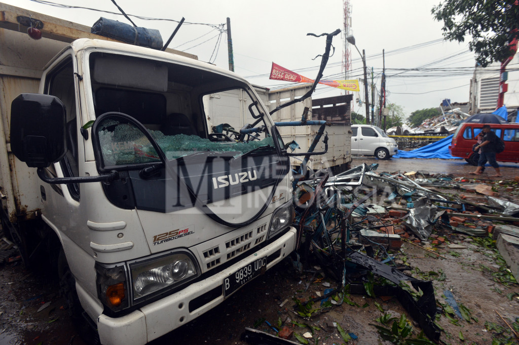 Kendaraan yang berada di seberang bangunan rusak berat di Jalan Raya Hankam, Jati Melati, Bekasi, Jawa Barat, Minggu (23/10/2016)