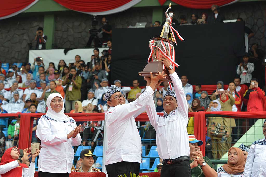 Mensos Khofifah Indar Parawansa menyaksikan Gubernur Jabar Ahmad Heryawan dan Ketua Umum NPCI Jabar Ukun Rukaendi mengangkat piala juara umum pada acara penutupan Peparnas XV.